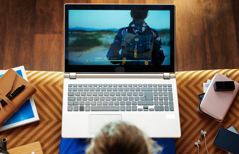 aerial shot of a young woman watching a movie on her laptop - documentaries