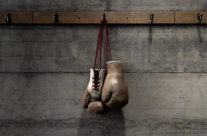 old fashioned boxing gloves hanging alone on a hook in a concrete gym - Muhammad Ali