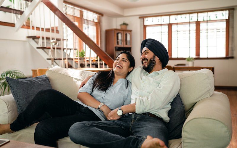 Comedy Sitcom, two people laughing on couch watching sitcom comedy recovery